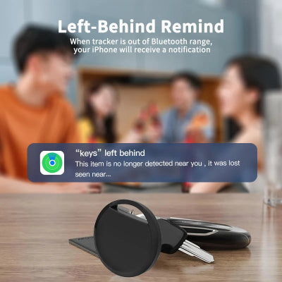 Keychain tracker with smartphone notification on a table, people in the background