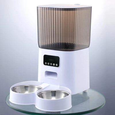 Pet feeder with two bowls on a glass surface against a light gray background